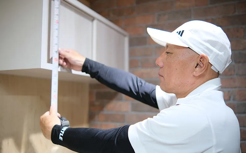 棚の寸法をメジャーで測る大工