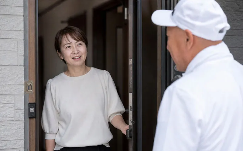 リフォームを引き受けたお宅のご近所の奥様にあいさつ回りをする大工